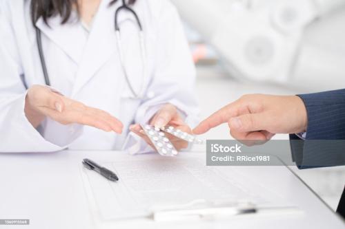 Female doctor and male patient explaining prescription drugs